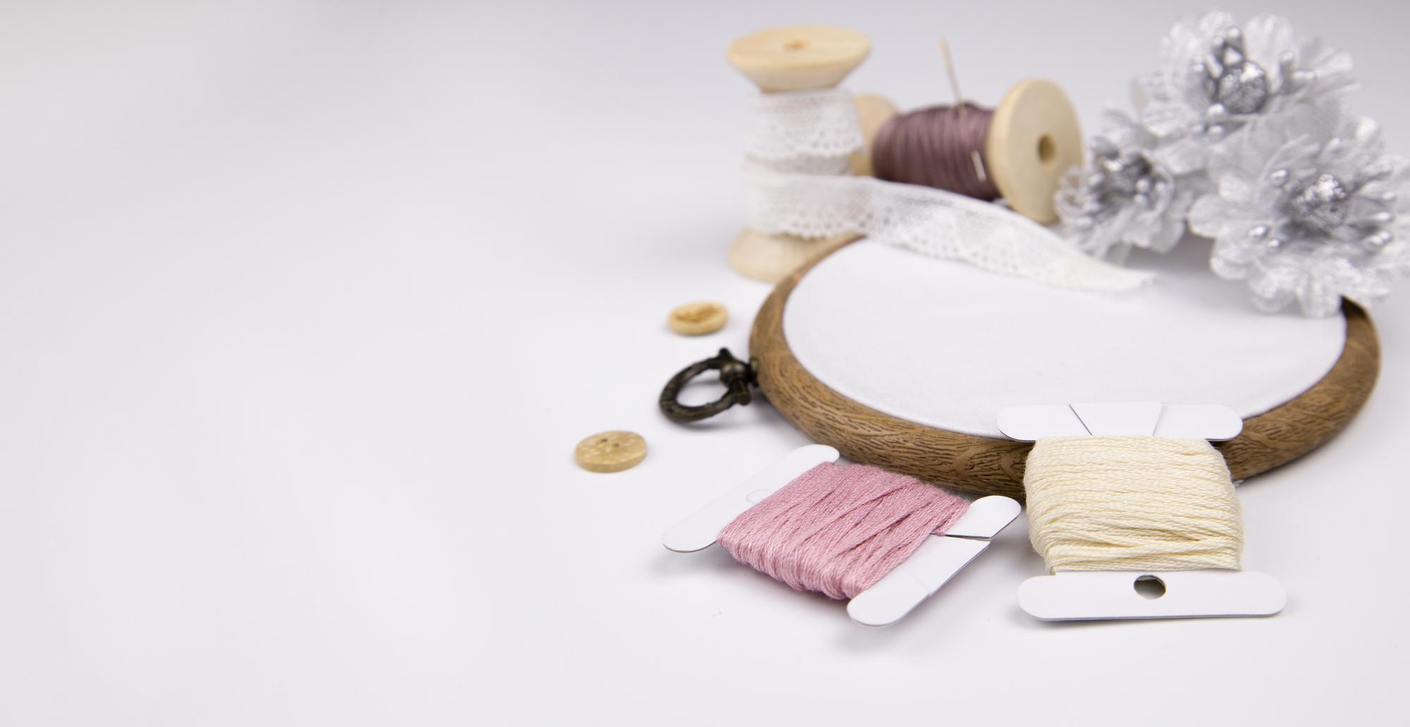 Atelierarbeitstisch mit Garnspulen und Stickrahmen